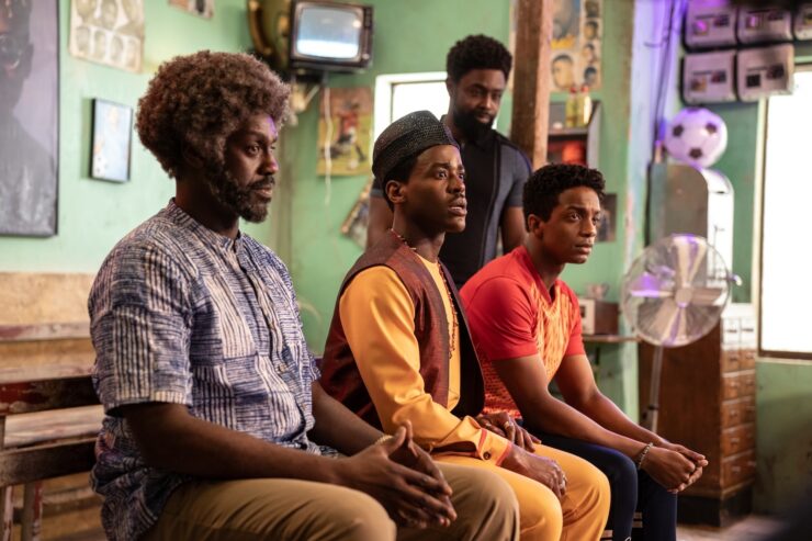 Omo, the Doctor, Amaka, and Tunde waiting for the haircut in Doctor Who's "The Story and the Engine"